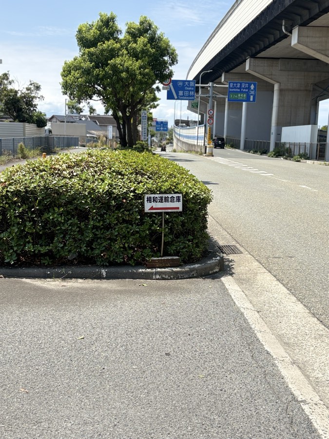 植え込みの前に立つ相和運輸倉庫の案内看板